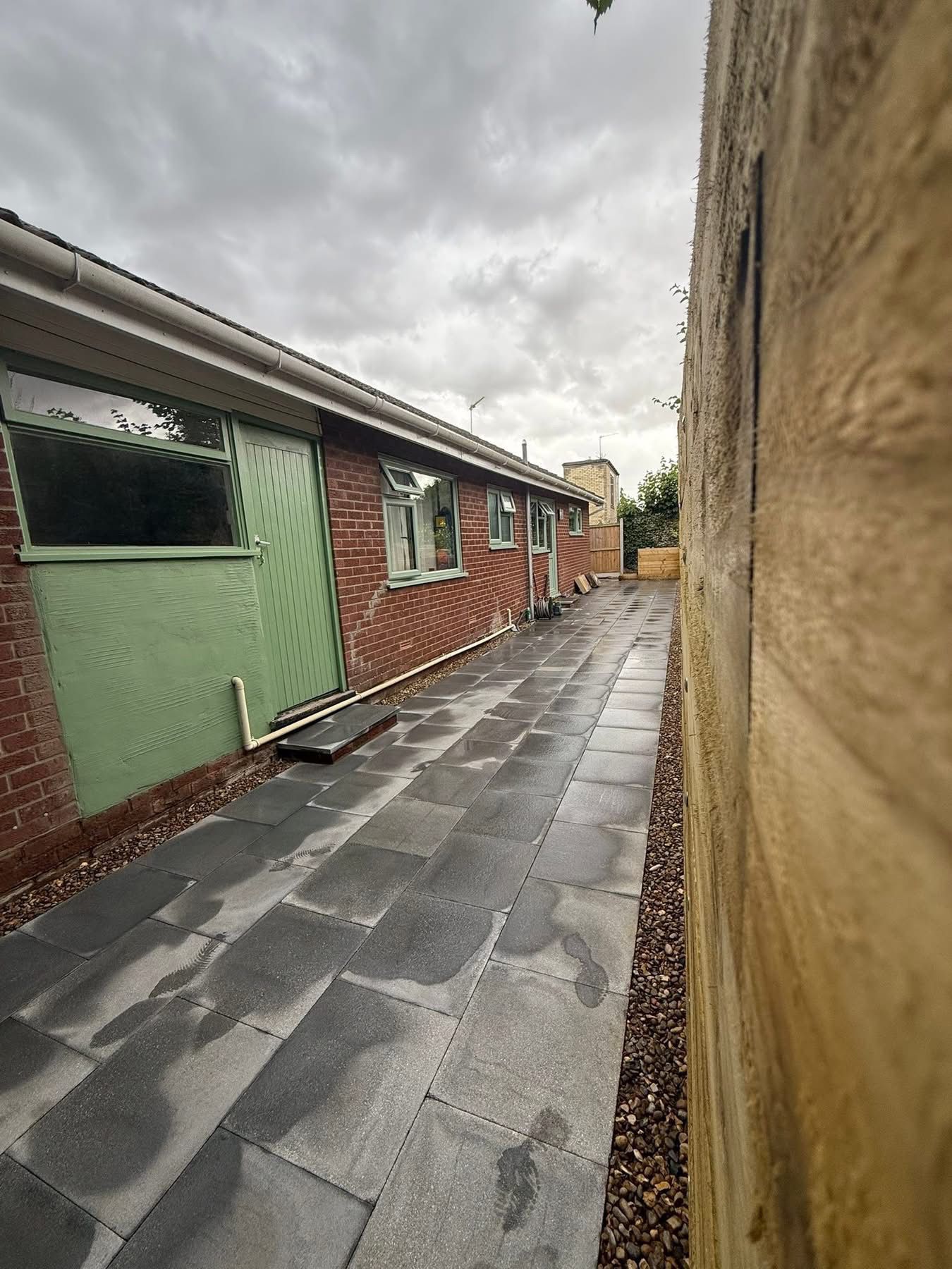 Beautiful natural stone patio installation in a Glasgow garden with outdoor furniture by Oaklands Treecare