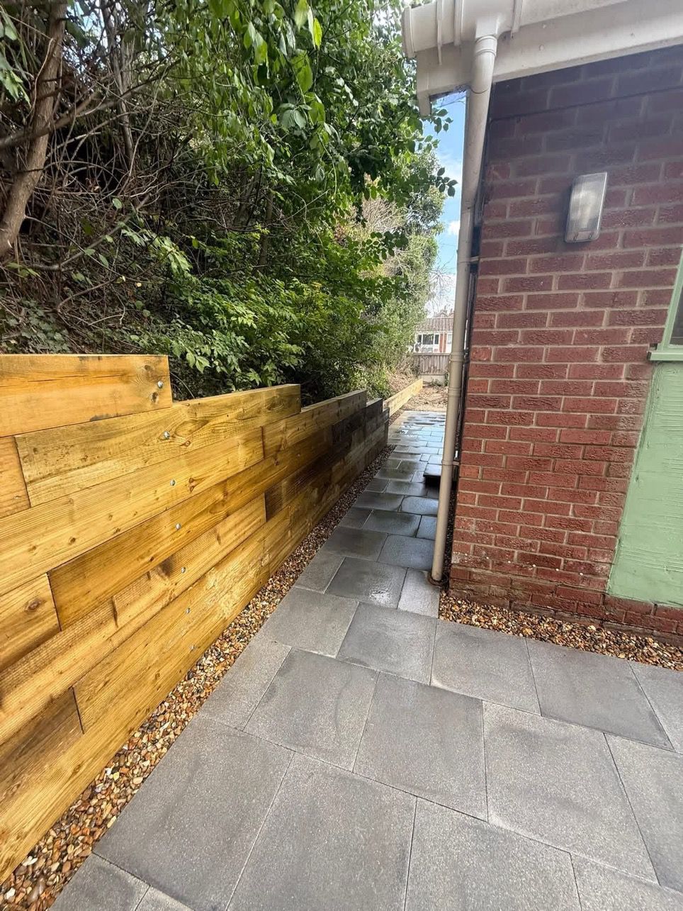 Timber sleeper retaining wall with stepped patio in a Glasgow garden by Oaklands Treecare